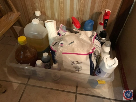 Tote containing Pine Sol, napkins, and assorted cleaning supplies