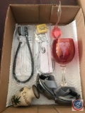 [2] gun locks, pair of safety glasses, a weather swan, a Disney wine glass and a small Chihuahua pot