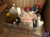 Tote containing Pine Sol, napkins, and assorted cleaning supplies