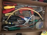 Flat containing screwdrivers, clamps, and assorted hardware