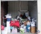 10x10 unit containing luggage, hangers, clothing rack, dog bed, baskets, ladies clothing, plastic