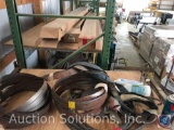 Stack of appx 12 lenox 11 ft by 1 inch band saw blades, 1 safety harness, 1 cable choker, and