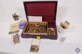 Wooden box containing an assortment of live rounds, empty brass including 50 cal shells and primers