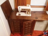 Singer Deluxe Zig Zag (model 640) sewing machine in cabinet with assorted sewing supplies