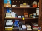 Contents of 3 shelves to include assorted office supplies- correction pens, binder clips, battery