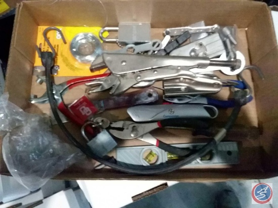 Flat containing box cutters, vise grip, level, pliers, putty knife, locks and more