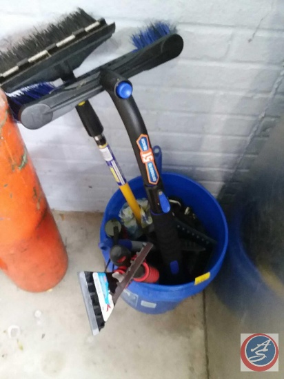 Bucket containing ice scrappers, long handled car brushes and more