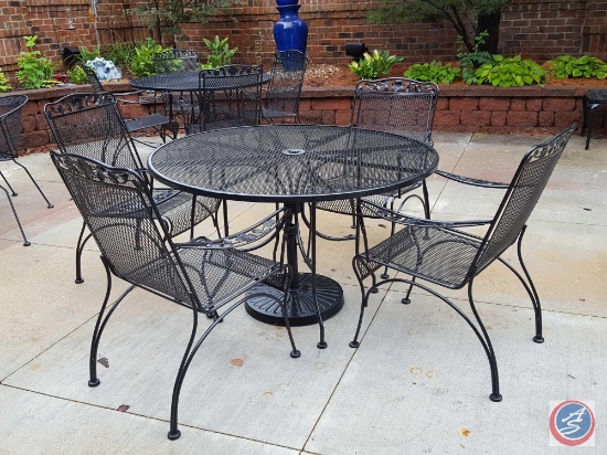 7 pc. Wrought iron patio set: round table and (4) chairs, brown and green print umbrella w/ stand