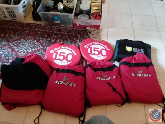 Basket containing (4) Husker blankets (3 with carrying bags), (2) bleacher cushions, bleacher