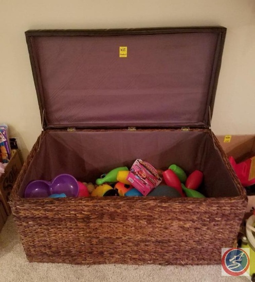 Wicker toy box containing a variety of balls, Rawlings fastback baseball glove, plastic bowling game