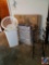 Furnace Filter, stack of Uhaul boxes, and kitchen Trash Can, black metal decorative buggy plant