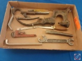 Assorted items in flat, Chisel, knife, pipe wrench, open ended wrench.