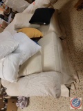 white loveseat couch with assorted loose throw pillows approx 8...