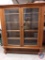 Antique distinctive oak bookcase w/ 2 glass doors & 5 shelves. 28 spindles around the base. 28