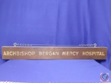 Wooden Sign ?Archbishop Bergan Mercy Hospital.? Wood w/ gold lettering. 42? wide x 5.?