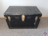 Large black flattop steamer trunk w/ metal fittings. Worn handles, inside tray & no key. Torn