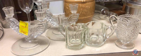 Two depression glass candleholders, depression glass matching cream and sugar, and a depression
