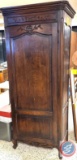 Free standing armoire. There are two shelves resting on top and two metal shelves sitting in the