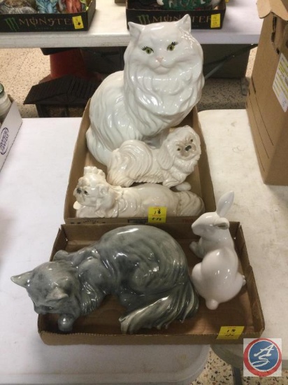 Animal figurines. Including cats, dogs, and rabbit. The gray cat figurine does appear to sit