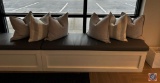 Assortment of decorative pillows. Four of them are a plain gray, two of the pillows are white and