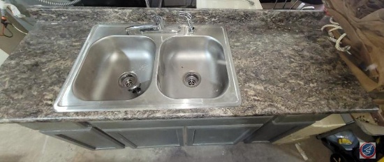 Double stainless-steel sink and countertop with cabinet.