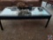 Mirrored coffee table, with metal basket , cords and decor on top of it.