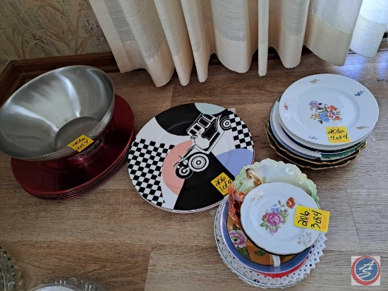 Assortment of decorative plates, charger plates, and a metal bowl. There are a variety of designs of