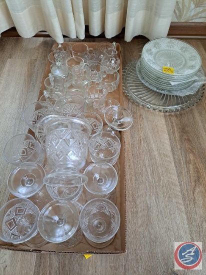 Assortment of clear glass dishes. Dishes include, mugs, stemmed glasses, cream and sugar dishes,