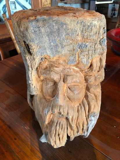 Hand carved old man of the north Face in log.