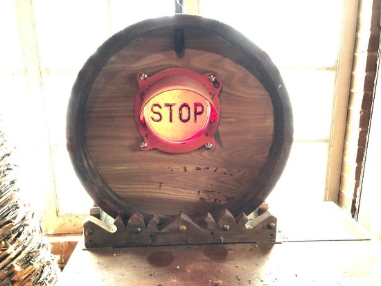 Vintage train stop sign mounted in large mold on wood stand.