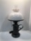 Electric hurricane style lamp with plastic shade and glass globe