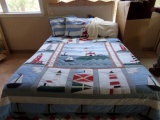 FULL SIZE BED WITH WICKER AND CARVED HEADBOARD AND LIGHTHOUSE MOTIFF LINENS