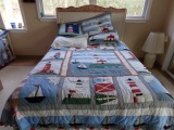 FULL SIZE BED WITH WICKER AND CARVED HEADBOARD AND LIGHTHOUSE MOTIFF LINENS