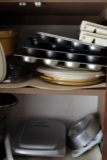 CONTENTS OF CABINET INCLUDING LARGE LOT COOKWARE MUFFIN TINS STEAM POTS AND