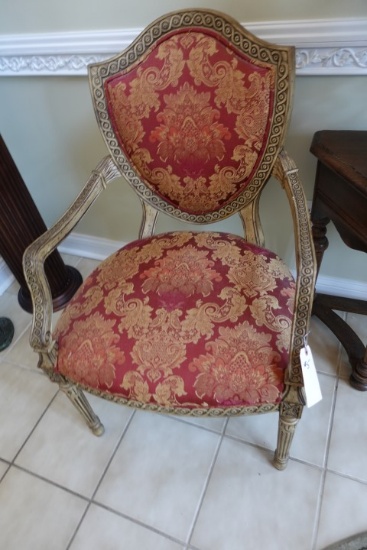 HEAVILY CARVED ARM CHAIR WITH RED AND GOLD UPHOLSTERY