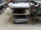 Contents of (2) Shelving Units, Including (1) Shelving Unit, Rolling Cart, and Table