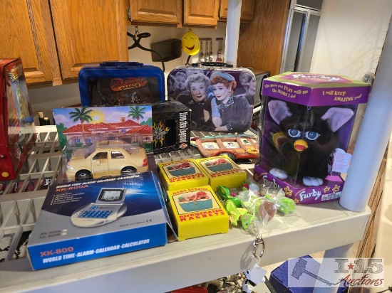 (2) Lunchboxes, Refrigerator Magnets, Harley Davison Ceramic Mugs, Furby, and The Chevron Cars Toy