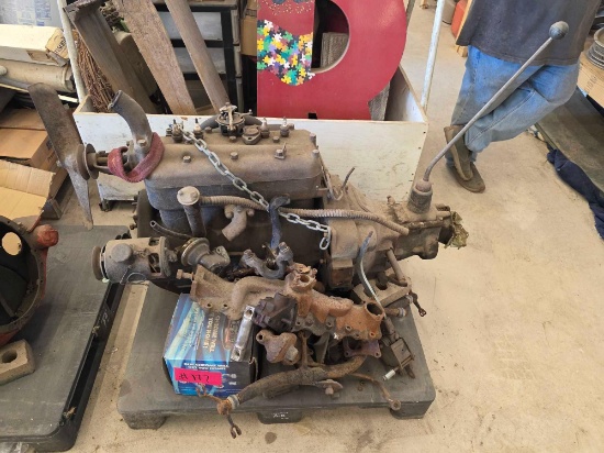 Vintage inline-four flathead engine block with an attached manual transmission and gear shifter