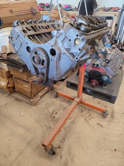 Cast iron V8 engine block mounted on a red engine stand