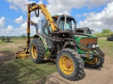 John Deere utility tractor equipped with a rear-mounted hydraulic boom arm and a rotary cutter head