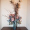 Faux Flowers and Peacock Feathers in Glass Vase