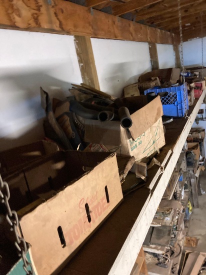 Long shelf of mostly vintage car parts bring ladder and people to get down