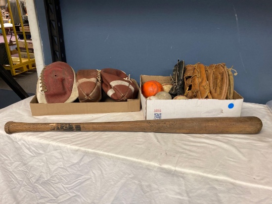 Footballs baseballs gloves and a bat