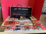 25 sets of playing cards and a partial grilling set