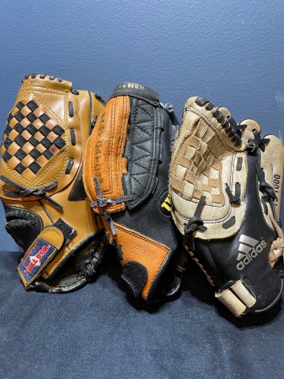 three children?s Little League baseball gloves