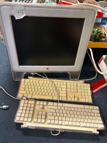Apple studio display monitor and two keyboards