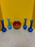 Four blue bud vases and a red vase