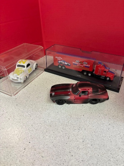 Three collectible racing cars, two in cases