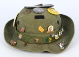 OD green Military hat adorned with vintage pins