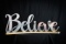 Believe Metal Curved Sign on Wood